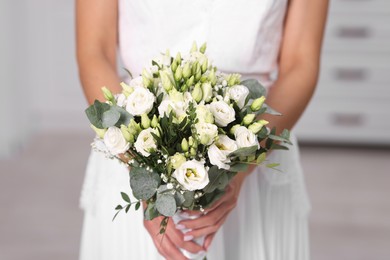 Photo of Bride with beautiful wedding bouquet on light background, closeup