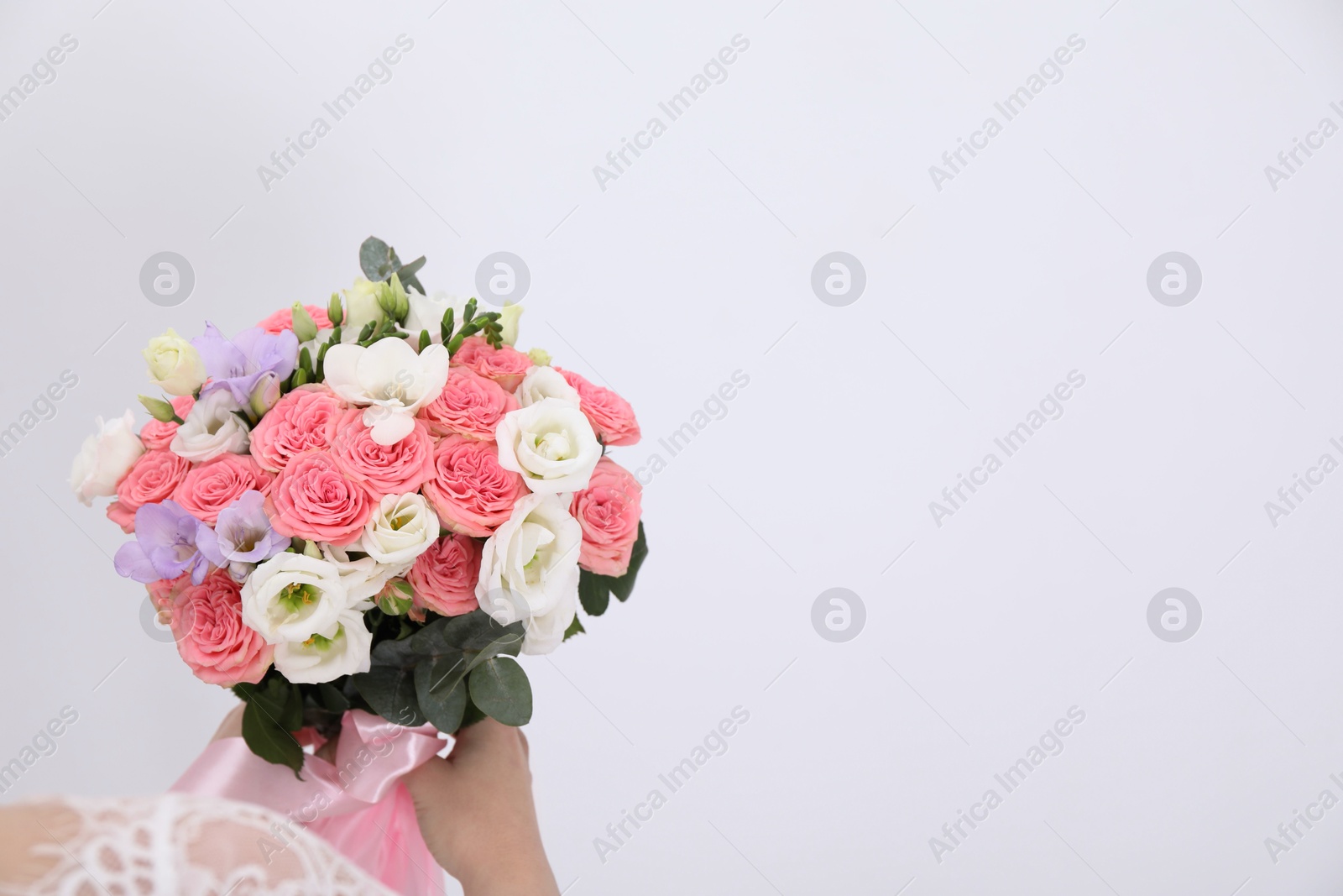 Photo of Bride with beautiful wedding bouquet on light background, closeup. Space for text