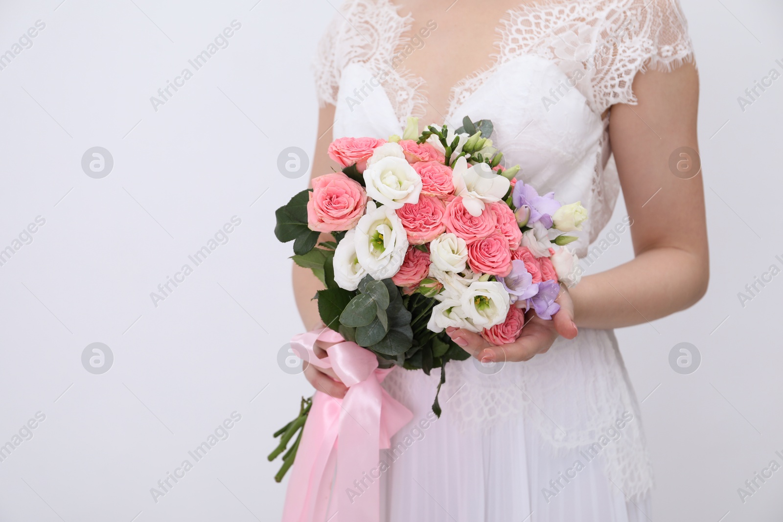 Photo of Bride with beautiful wedding bouquet on light background, closeup. Space for text