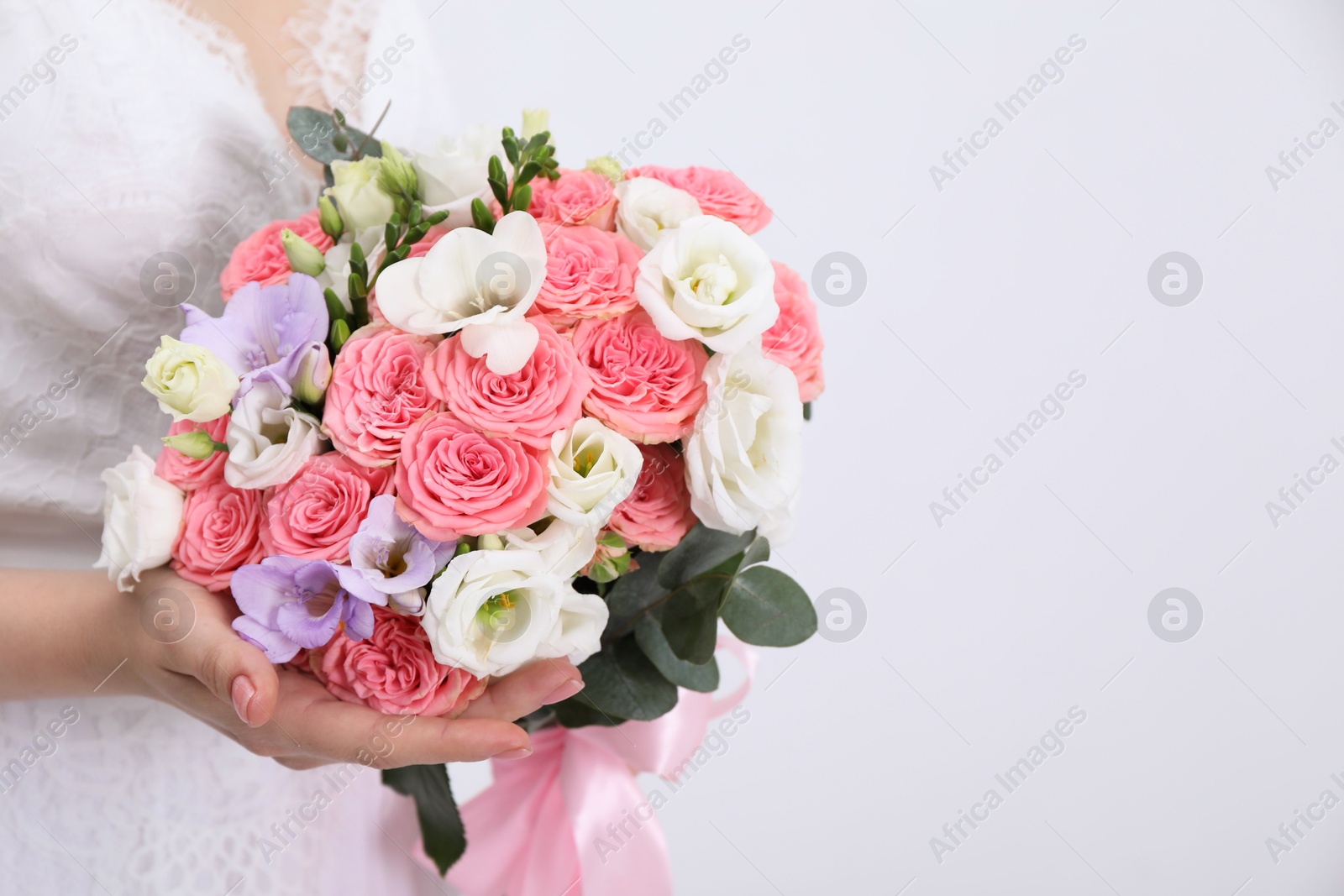 Photo of Bride with beautiful wedding bouquet on light background, closeup. Space for text