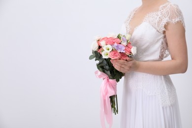 Photo of Bride with beautiful wedding bouquet on light background, closeup. Space for text