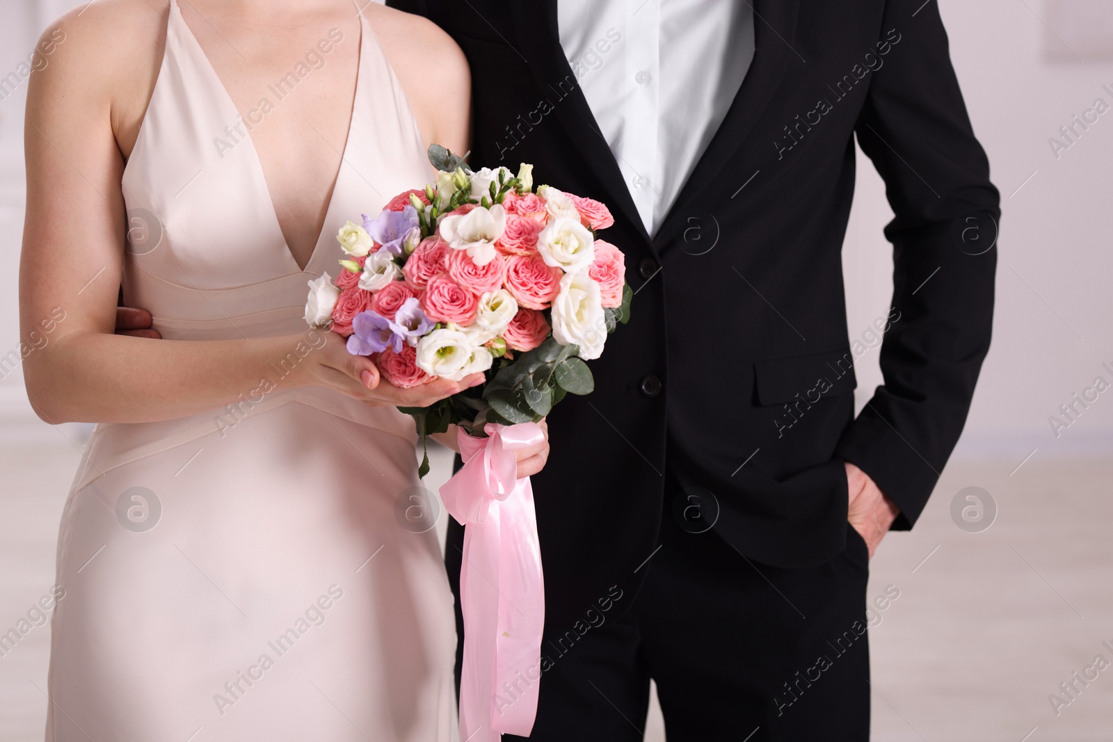 Photo of Bride with beautiful wedding bouquet and groom indoors, closeup