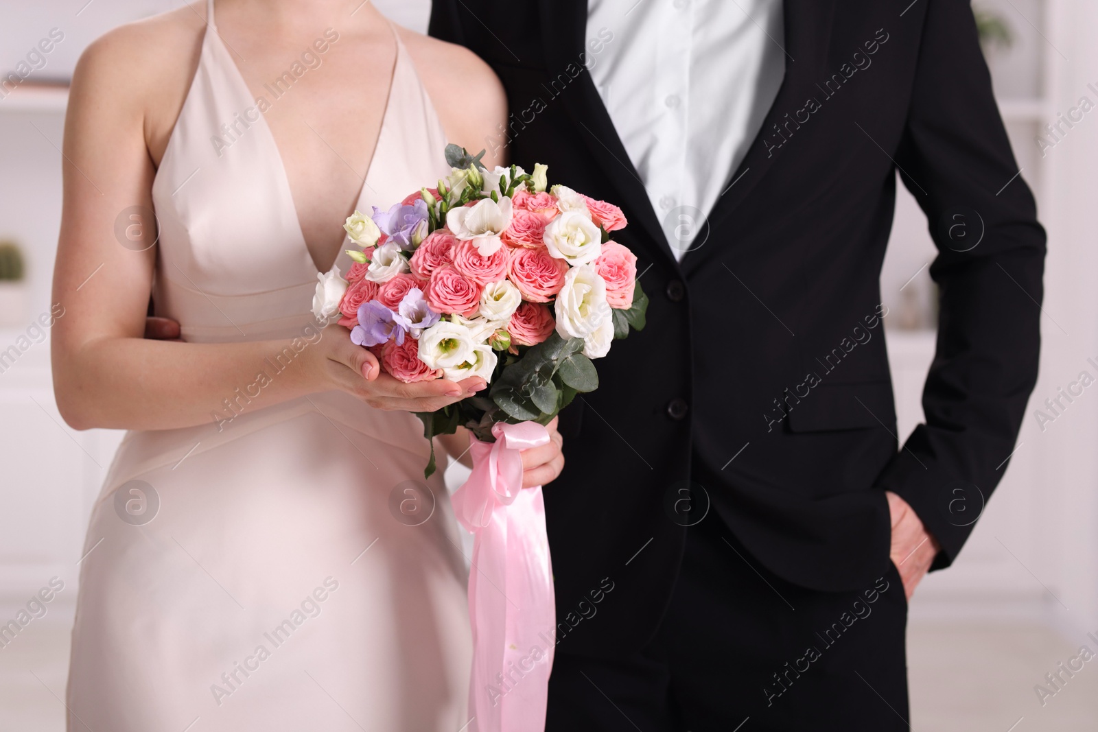 Photo of Bride with beautiful wedding bouquet and groom indoors, closeup