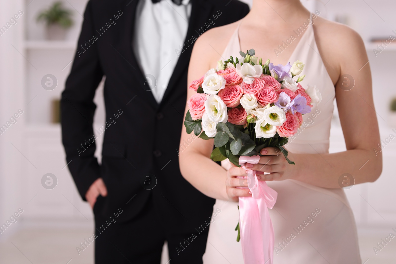 Bride with beautiful wedding bouquet and groom indoors, closeup Photo of Bride with beautiful wedding bouquet and groom indoors, closeup