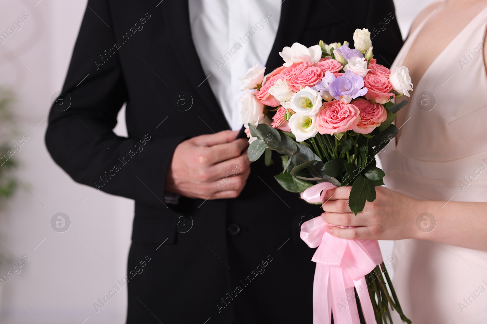 Photo of Bride with beautiful wedding bouquet and groom indoors, closeup