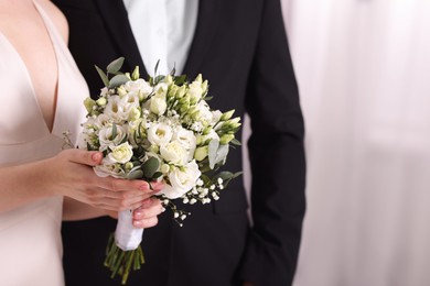 Photo of Bride with beautiful wedding bouquet and groom indoors, closeup. Space for text