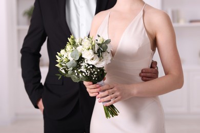 Photo of Bride with beautiful wedding bouquet and groom indoors, closeup