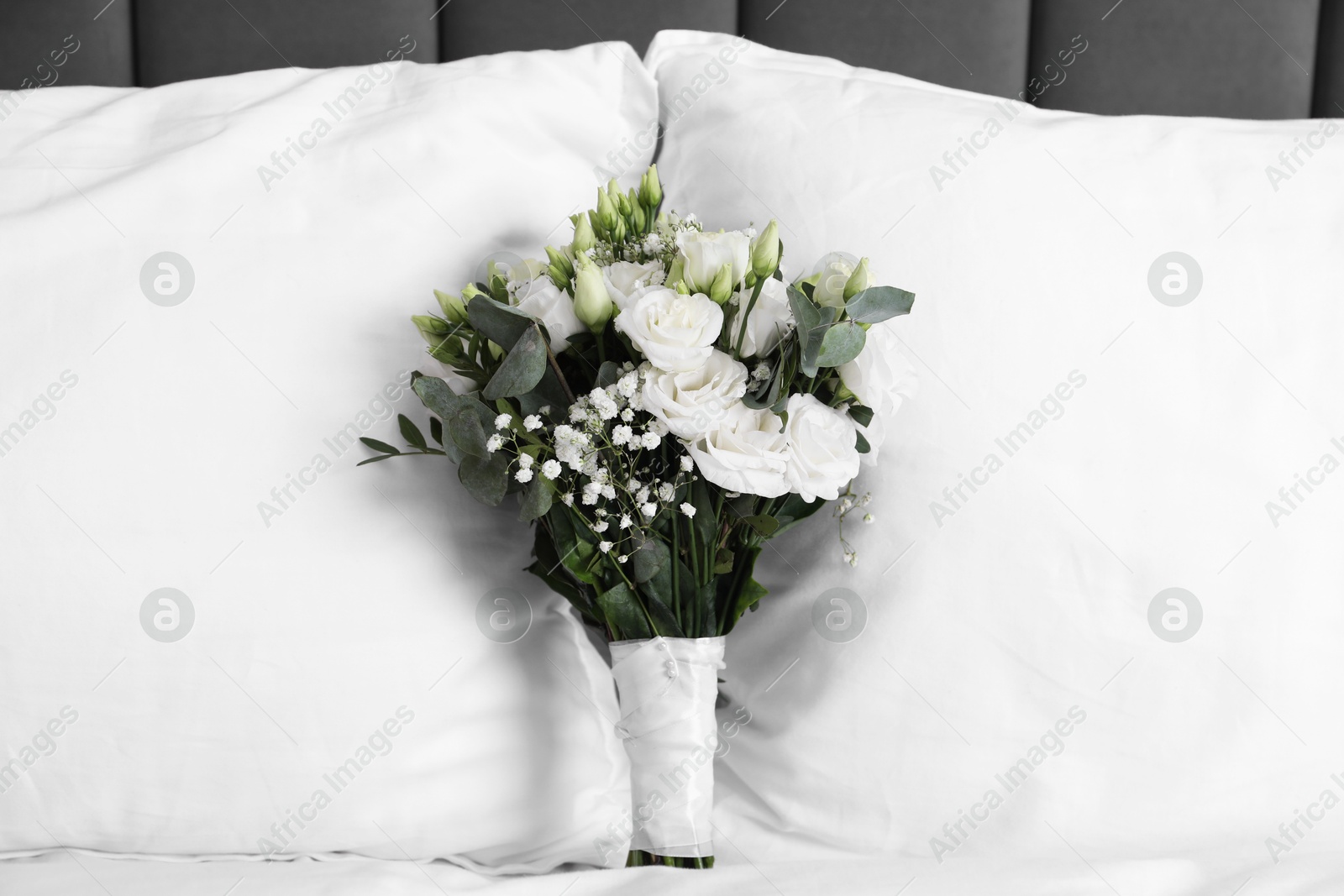 Photo of Wedding bouquet of beautiful flowers and pillows on bed