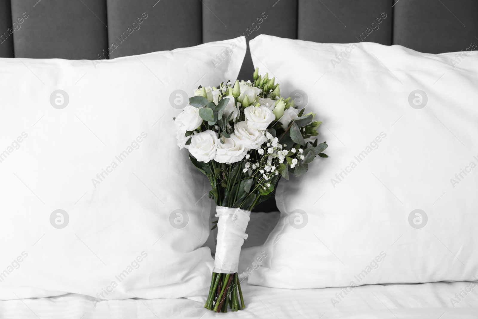 Photo of Wedding bouquet of beautiful flowers and pillows on bed