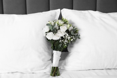 Photo of Wedding bouquet of beautiful flowers and pillows on bed