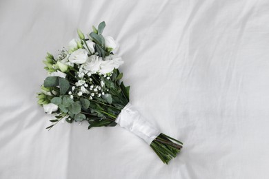 Photo of Wedding bouquet of beautiful flowers on linens, top view. Space for text