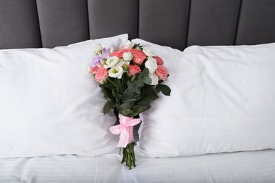 Photo of Wedding bouquet of beautiful flowers and pillows on bed