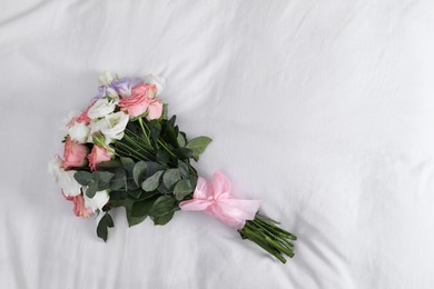 Photo of Wedding bouquet of beautiful flowers on linens, top view. Space for text