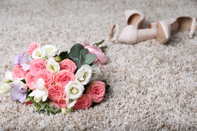 Photo of Wedding bouquet of beautiful flowers and bridal shoes on beige carpet, selective focus