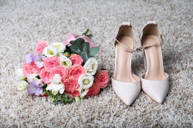 Photo of Wedding bouquet of beautiful flowers and bridal shoes on beige carpet