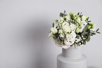 Photo of Wedding bouquet of beautiful flowers in vase against grey wall, closeup. Space for text