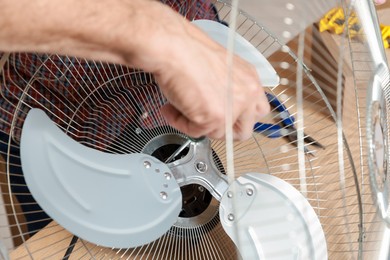 Photo of Relaxing hobby. Senior man repairing fan with screwdriver in workshop, closeup