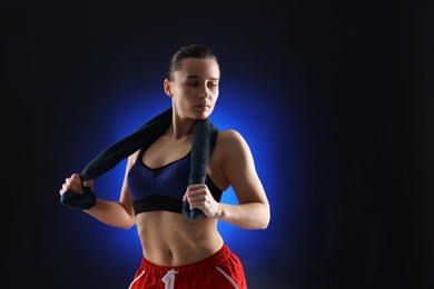 Photo of Sporty woman with terry towel on dark blue background, space for text