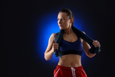 Photo of Sporty woman with terry towel on dark blue background, space for text