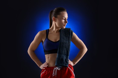 Photo of Sporty woman with terry towel on dark blue background