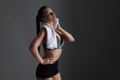 Photo of Sporty woman with terry towel on dark grey background. Space for text