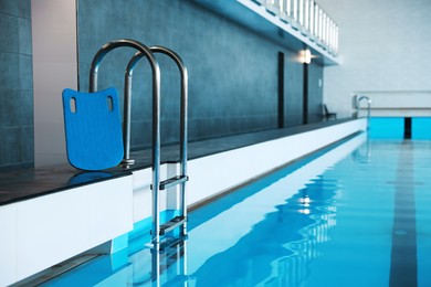 Photo of Swimming pool with clean water and ladder indoors