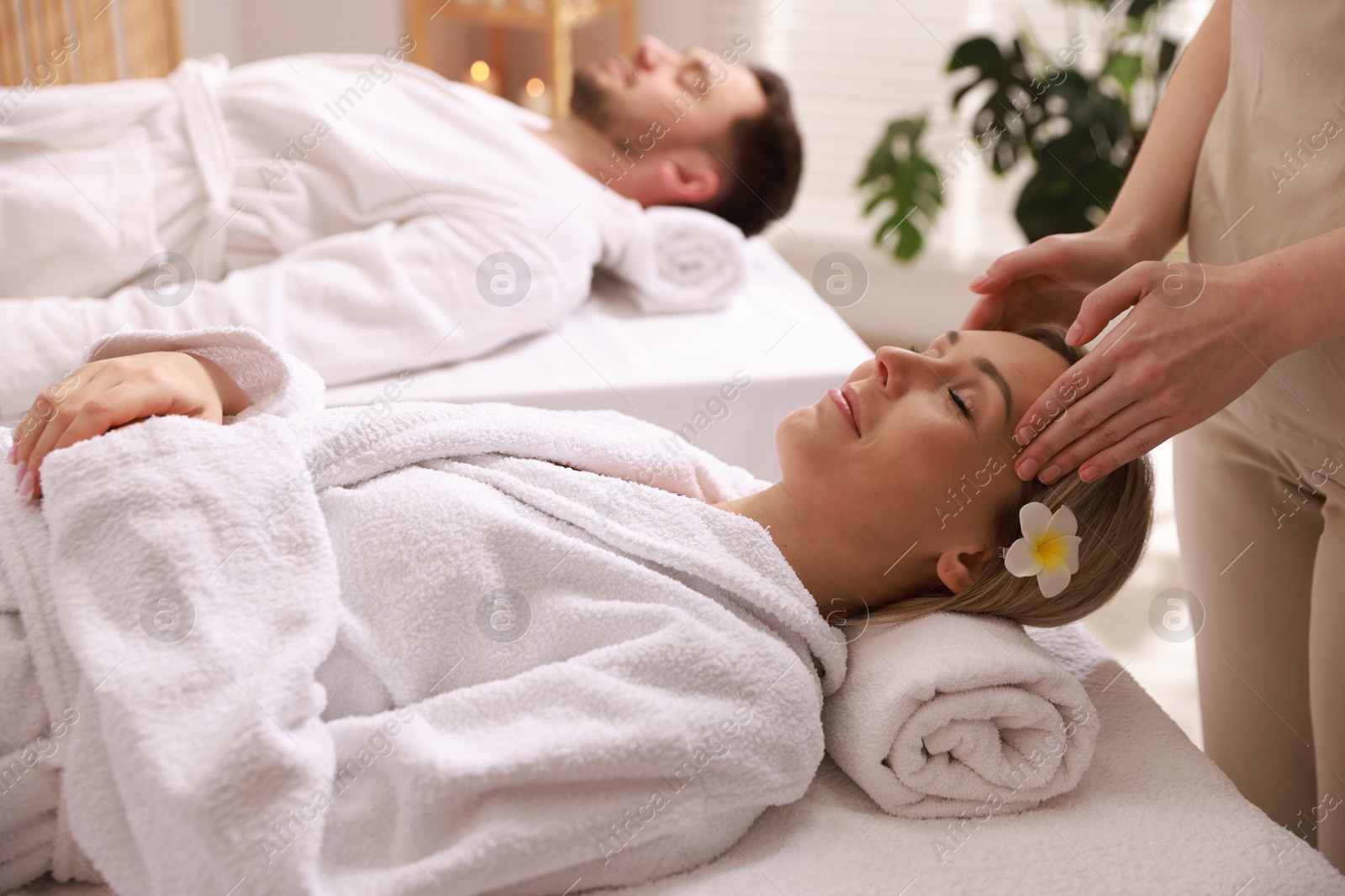 Photo of Couple receiving relaxing massage in spa salon, selective focus