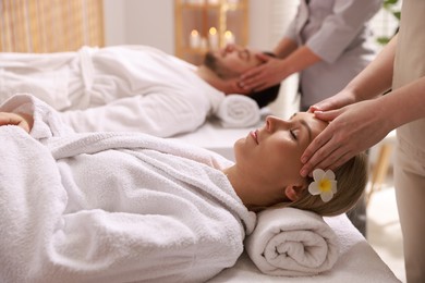 Photo of Couple receiving relaxing massage in spa salon, selective focus