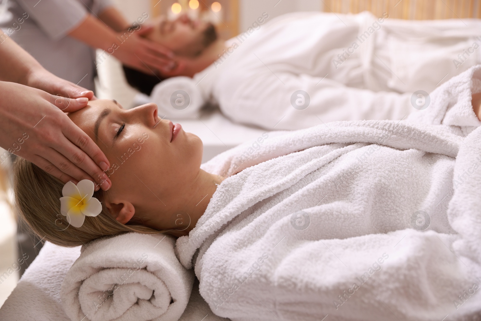 Photo of Couple receiving relaxing massage in spa salon, selective focus