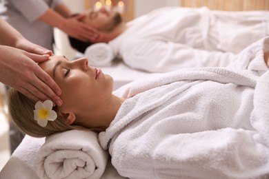 Photo of Couple receiving relaxing massage in spa salon, selective focus