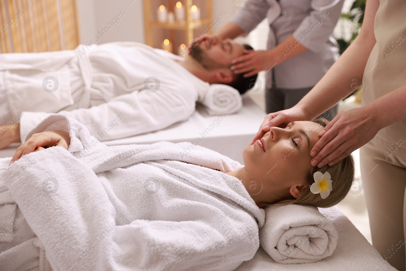 Photo of Couple receiving relaxing massage in spa salon, selective focus