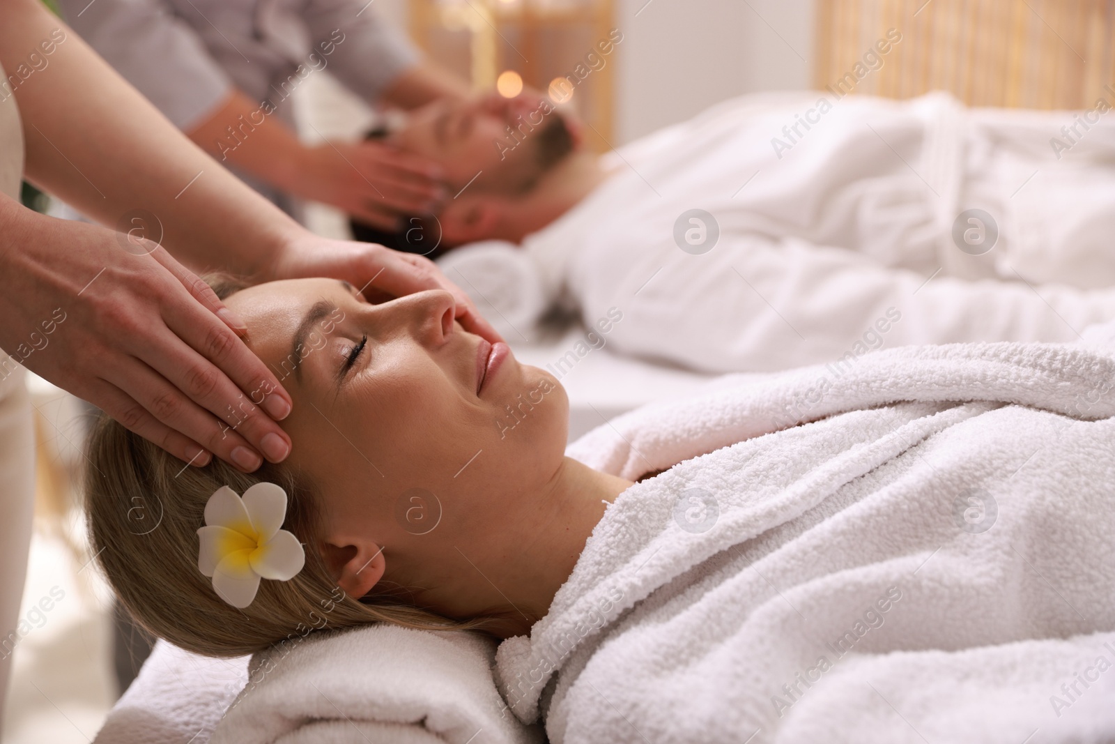 Photo of Couple receiving relaxing massage in spa salon, selective focus