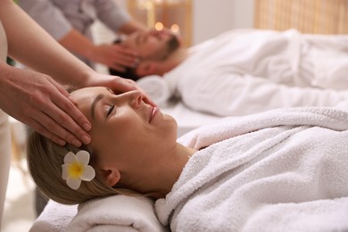 Photo of Couple receiving relaxing massage in spa salon, selective focus