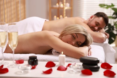 Photo of Couple lying on massage tables in spa salon, selective focus