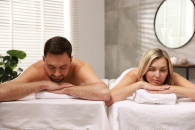 Photo of Couple lying on massage tables in spa salon