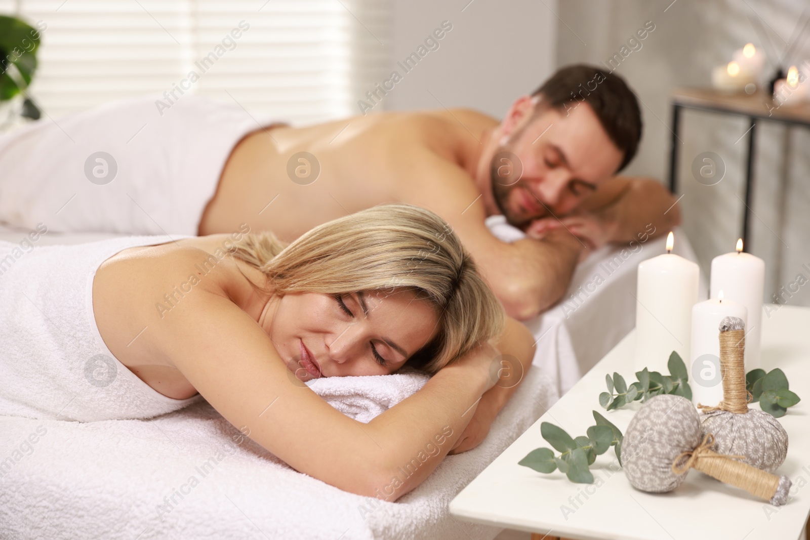 Photo of Couple lying on massage tables in spa salon, selective focus