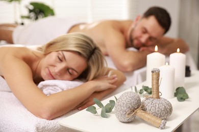 Photo of Couple lying on massage tables in spa salon, selective focus