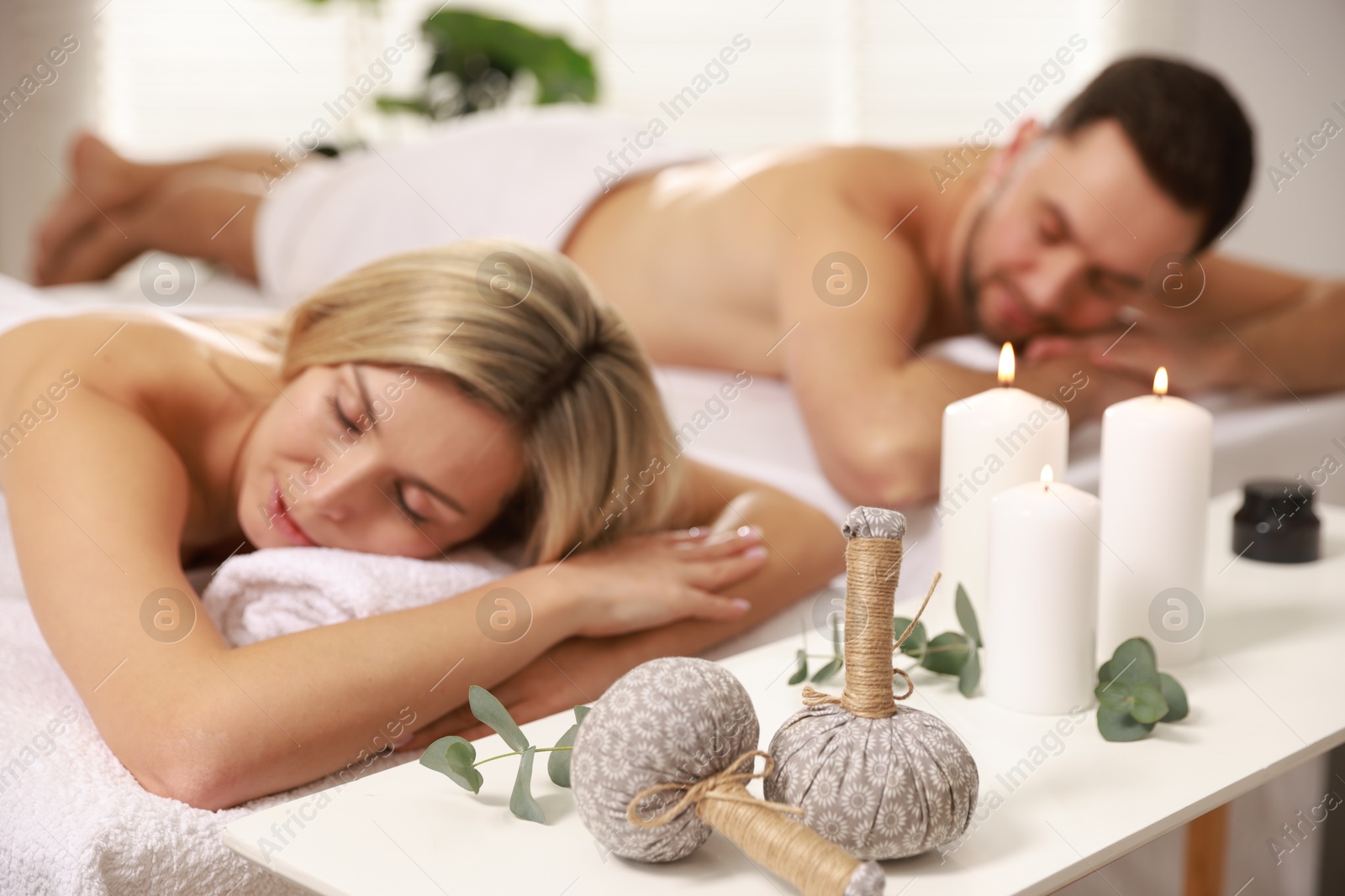 Photo of Couple lying on massage tables in spa salon, selective focus