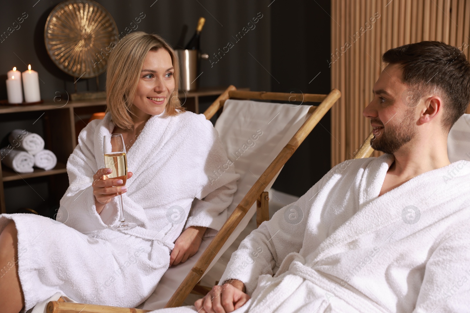 Photo of Happy couple in bathrobes relaxing in spa salon