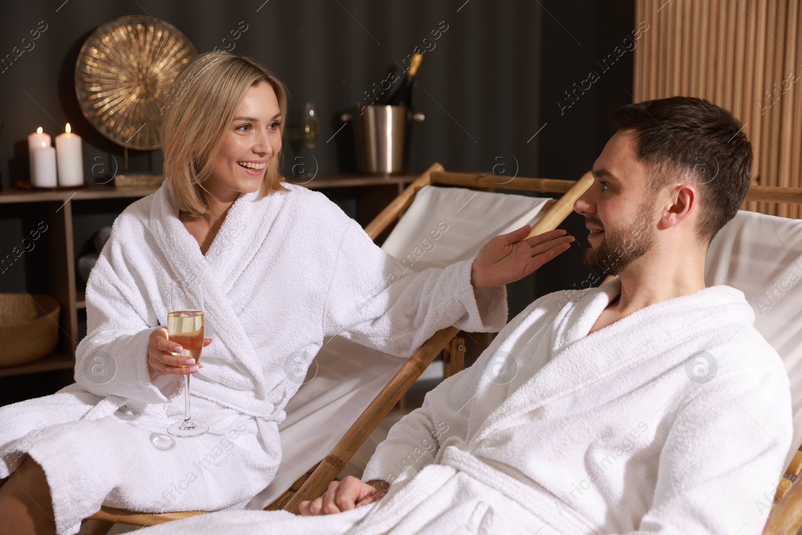 Photo of Happy couple in bathrobes relaxing in spa salon