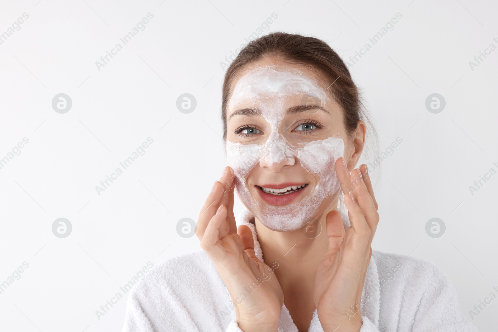 Photo of Spa day. Beautiful woman applying mask onto her face on white background, space for text