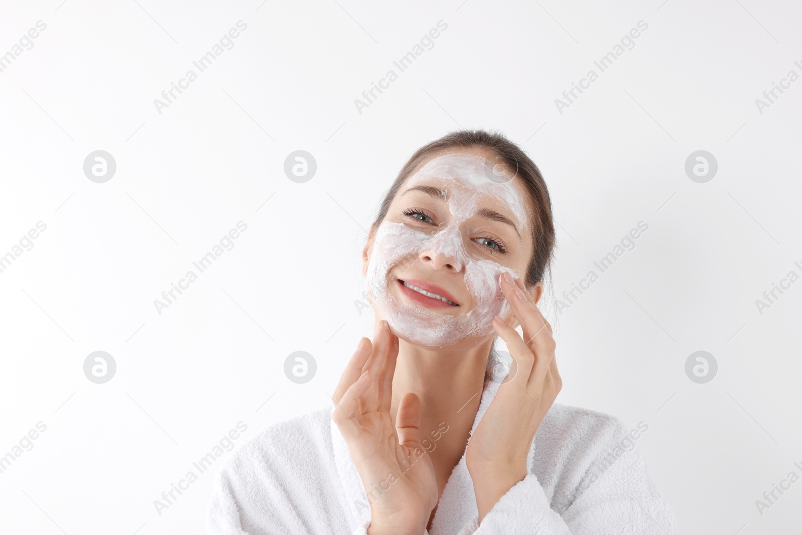 Photo of Spa day. Beautiful woman applying mask onto her face on white background