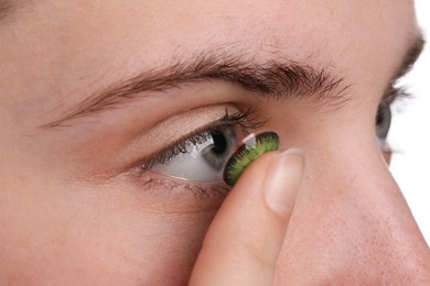 Photo of Woman putting in green color contact lens, closeup