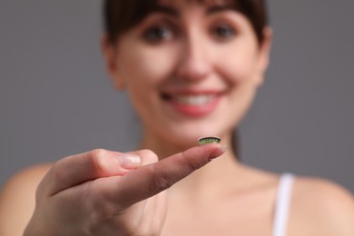 Photo of Woman with green color contact lens on grey background, selective focus