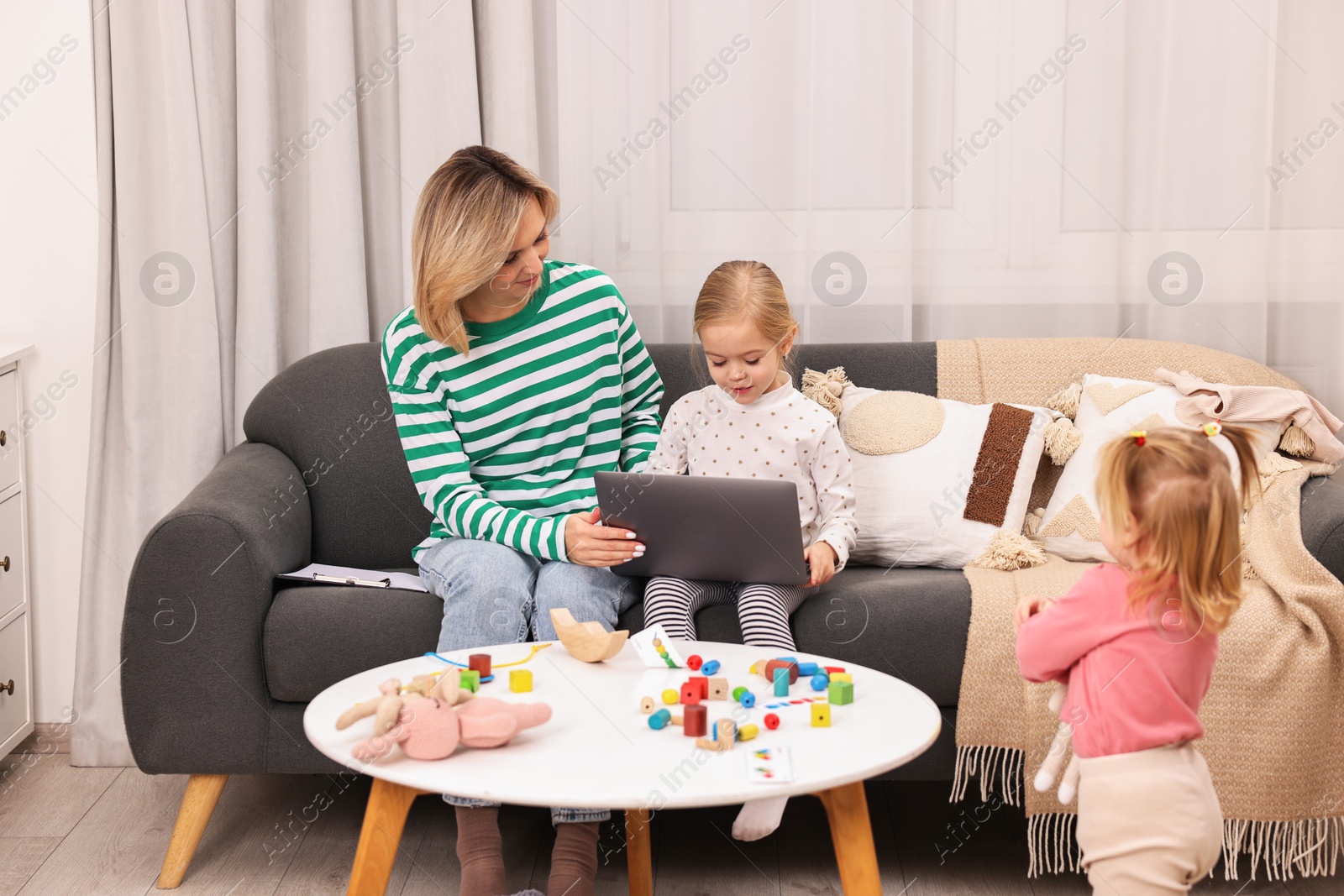 Photo of Work at home. Single mother with her children on sofa indoors