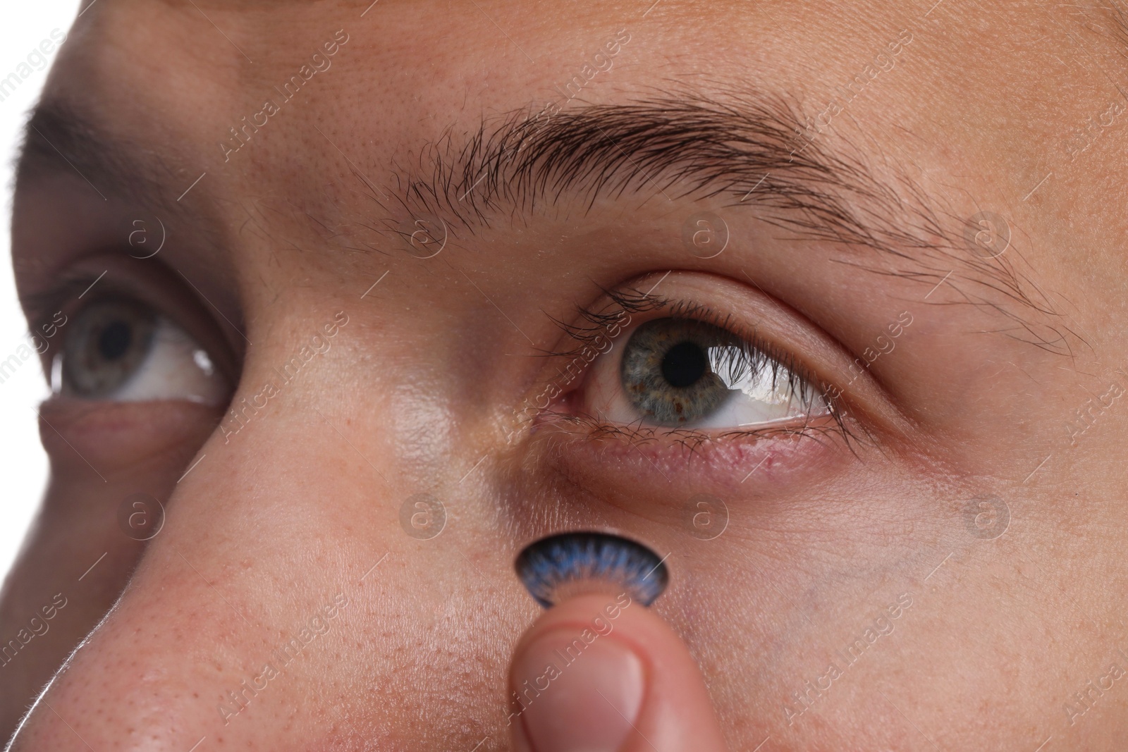 Photo of Man putting color contact lens in his eye, closeup