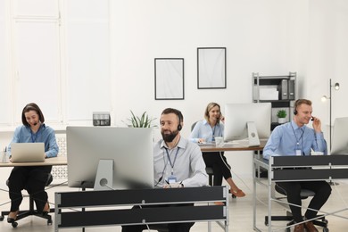 Photo of Technical support call center. Team of operators working in office