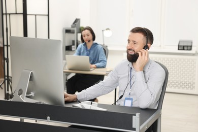 Photo of Technical support call center. Smiling operator working in office