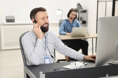 Photo of Technical support call center. Smiling operator working in office