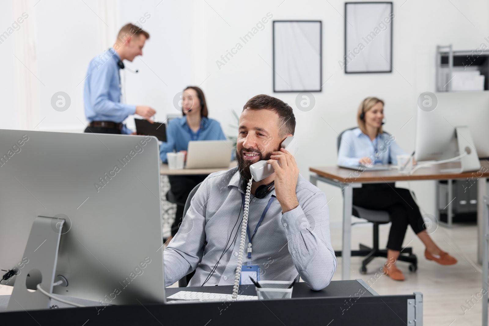 Photo of Technical support call center. Team of operators working in office